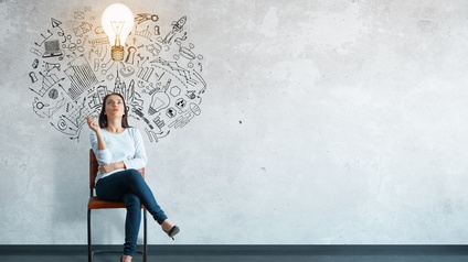 Eine Person mit dunklen Haaren sitzt auf einem Sessel vor einer hellen Wand und blickt nach oben. Über ihr sind unter anderem Illustrationen einer Glühbirne, einer Rakete, eines Laptops, von Puzzlestücken, eines Türschlosses, verschiedene Diagramme etc