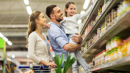 Junge Familie, Eltern und ein Kind, beim Einkaufen im Supermarkt