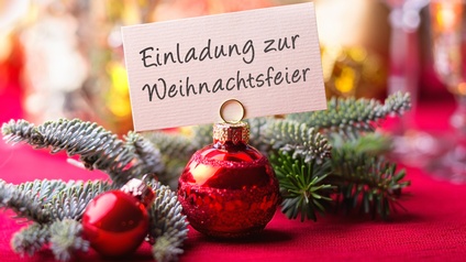 Einladung zur Weihnachtsfeier mit Tannenzweigen und Christbaumschmuck auf rotem Untergrund