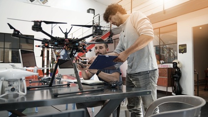 Personen arbeiten an einer Drohne in einem Büro