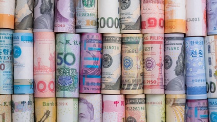 Detailaufnahme von zusammengerollten Geldscheinen aus unterschiedlichen Währungen von verschiedenen Ländern der Welt