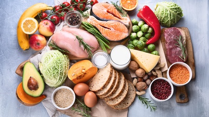 Verschiedene Lebensmittel arrangiert auf einem gestrichenen Untergrund