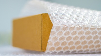Nahaufnahme eines kleinen Kartons, der in Luftpolster eingewickelt ist