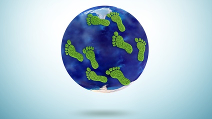 Grafik der Erde und Fußabdrücken, die grün sind und in Grasoptik gestaltet sind