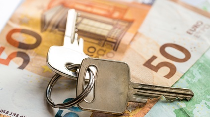 Zwei Schlüssel mit Metallring verbunden auf 50- und 100-Euro-Scheinen platziert