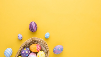 Osternest mit bemalten Ostereiern, Hintergrund gelb