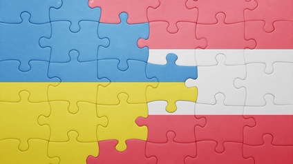 Zusammengesetztes Puzzle das die Flaggen der Ukraine und Österreichs ineinander verlaufen lässt: Links blaugelb, rechts rotweißrot gestreift
