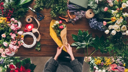 Person in Floristikhandlung bindet einen Blumenstrauß aus verschiedenen Blumen, Topshot, Vogelperspektive