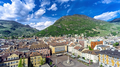 Stadtansicht Bozen: Ein Blick von oben auf den historischen Hauptplatz, die Piazza Walther, der Stadt Bozen, Hauptstadt der Region Trentino-Südtirol. Gelegen vor einem begrünten Berg unter blauem Himmel.<br />
