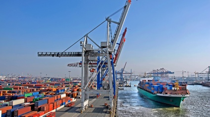 Container Terminal einer Werft, bunte Container und Frachtschiff im Wasser