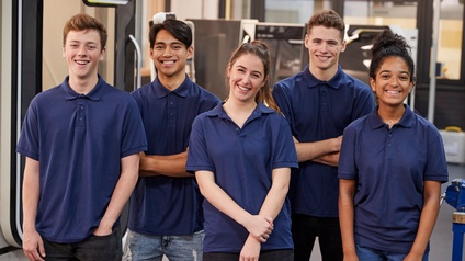 Porträt von fünf Personen. Jede Person trägt ein blaues Oberteil. Die Personen stehen in zwei Reihen. Alle haben die Mundwinkel leicht nach oben gezogen