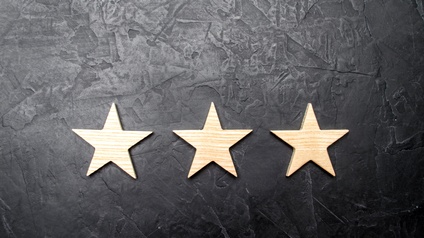 Drei Holzsterne auf einem schwarzen Untergrund