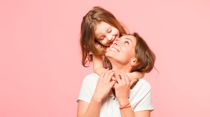 Mutter und Tochter vor lachsfarbenem Hintergrund