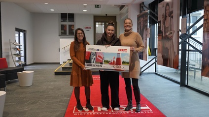 Foto mit Gewinnerin mit großem Scheck in der Hand und Vertreter der Wirtschaftskammer Kärnten