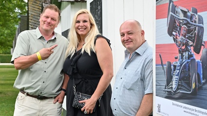 Neuwirth, Engl-Kreuzer und Linzer vor einer weißen Badehütte im Strandbad mit einem der ausgestellten Fotos