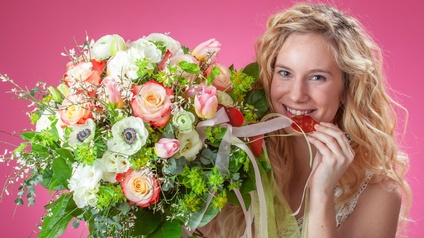 Junge Frau mit buntem Blumenstrauß zum Valentinstag