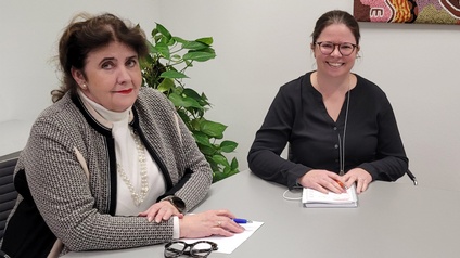 Zwei Personen sitzen am Tisch und unterhalten sich.