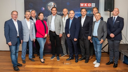 Gruppenfoto von elf Personen vor einem WKO NÖ‑Banner in einem Innenraum, nebeneinander stehend.