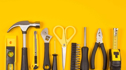 Verschiedene Werkzeuge vor einem gelben Hintergrund