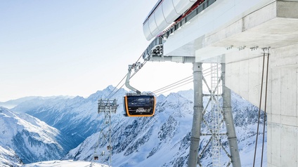 Seilbahn und beschneite Berge