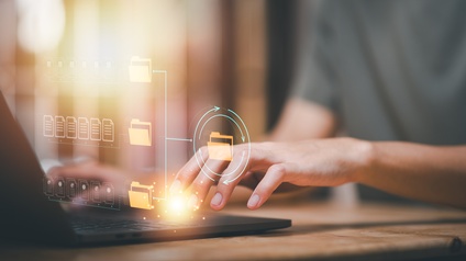 Nahaufnahme eines aufgeklappten Laptops mit grafischen Programmiericons.