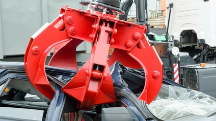 Ein Auto wird von einer großen, roten Kralle geschrottet