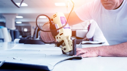Ein Schneider erstellt eine Schnittvorlage mit einem Elektrocutter