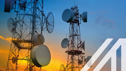 Telekommunikationstürme mit Funkantennen am Himmel bei Sonnenuntergang