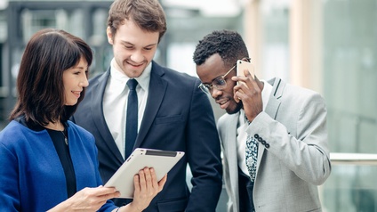 Drei Personen, zwei Männer und eine Frau, tauschen ihre Kontakte zu geschäftlichen Zwecken.