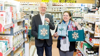 Man und Frau im Geschäft mit weihnachtlichen Tragetaschen