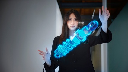 Person blickt auf Holographie einer blauen Spirale vor sich und hält beide Hände darum