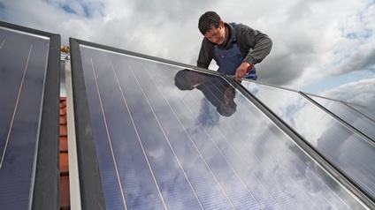 Solarkollektoren werden am Dach montiert.