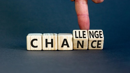 Fünf Holzwürfel auf einer dunklen Unterfläche nebeneinander. Die letzten beiden Würfel stehen leicht schräg. Auf jedem Würfel sind Buchstaben. Dadurch ergeben sich die Wörter 