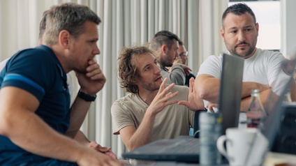 5 Personen sitzen vor Laptops