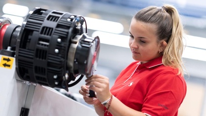 Frau in rotem Poloshirt arbeitet an der Maschine