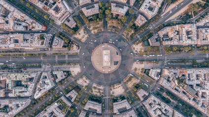 Top-Shot einer Stadtlandschaft mit einer Verkehrsinsel in der Mitte und davon sternförmig wegführend Straßen und Häuserblöcke