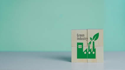 Auf Holzwürfeln ist eine grüne Fabrik aufgezeichnet. Daneben steht Green Industry