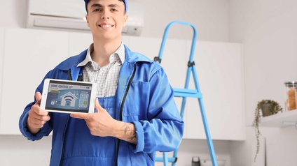 Elektriker mit einem Display für eine smarte Sicherheitsanlage in den Händen