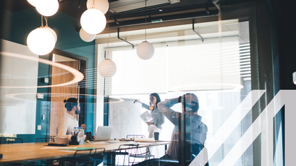 Geschäftsleute arbeiten mit Whiteboard und Dokumenten im Konferenzraum.