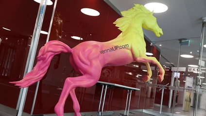 Pferdskulptur in rosa und gelb mit Text viennaUP.com auf dem Rücken
