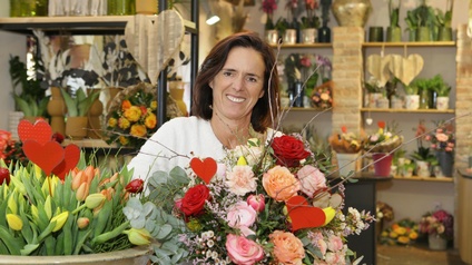 Landesinnungsmeister-Stellvertreterin Michaela Grandits inmitten einer Blütenpracht.
