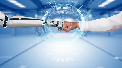 Zwei geballte Fäuste eines Roboterarms und eines Menschenarms treffen aufeinander