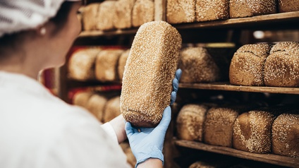 Eine Person begutachtet ein Brot zur Qualitätskontrolle