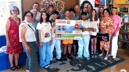Gruppenbild mit Spenden-Scheck