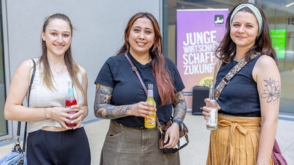 Drei Damen mit Drink in der Hand, im Hintergrund das JW-Rollup