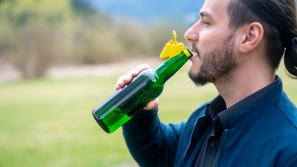 Silviu Reghin trinkt aus einer grünen Bierflasche mit gelbem Beerwilly-Verschluss