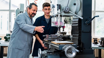 Lehrling an der Maschine mit Lehrlingswarth