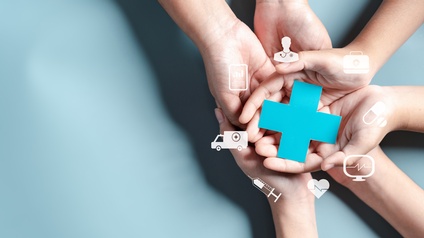 In der rechten Bildhälfte sind sechs Hände von drei Personen nach oben geöffnet und liegen übereinander. Die obersten Hände halten ein blaues Kreuz. Darum sind weitere weiße Symbolen kreisförmig angeordnet, zum Beispiel ein Krankenwagen, ein Koffer