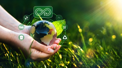 Hand hält eine virtuelle Weltkugel, die für Nachhaltigkeit und Kreislaufwirtschaft steht