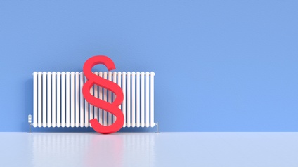 Rotes Paragrafenzeichen lehnt an Heizkörper vor blauer Wand